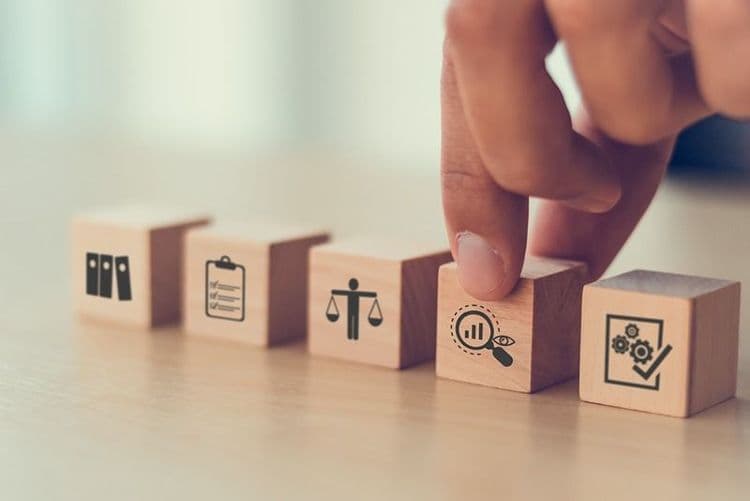 hand_selecting_wooden_blocks_with_icons_representing_financial_management_concepts